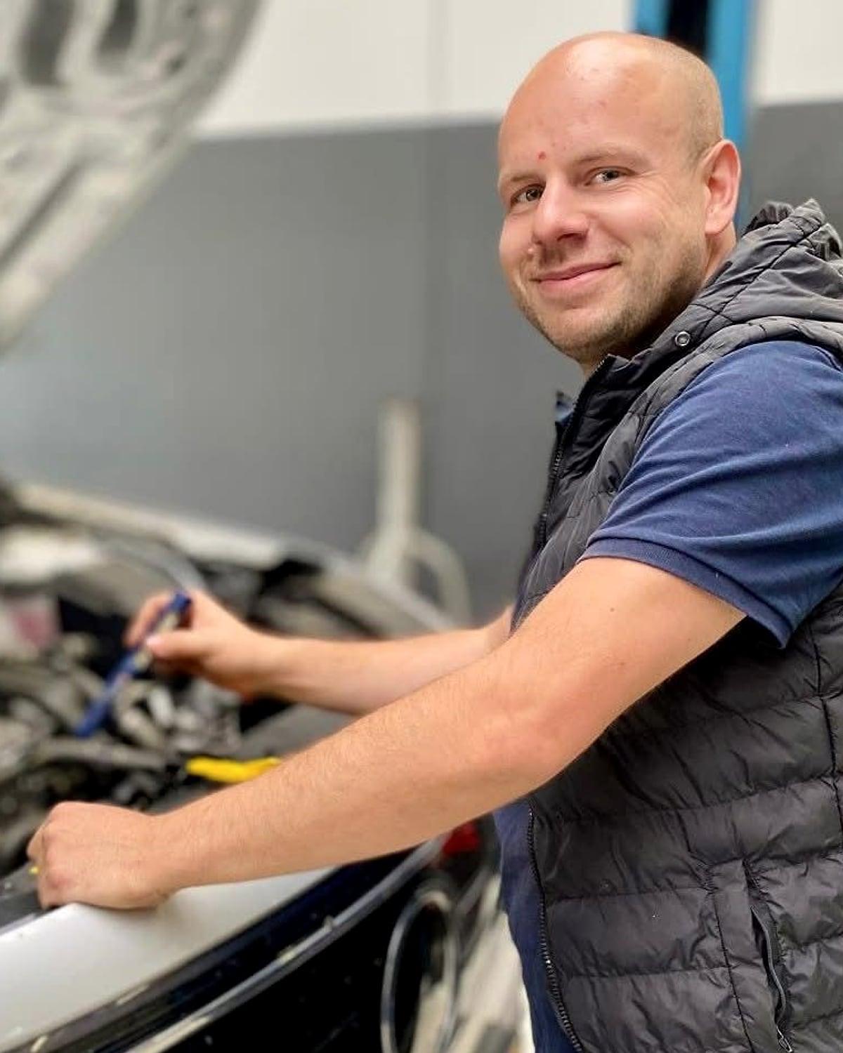 Roy Maas, eigenaar van Auto Plus Limburg, aan het werk onder de motorkap